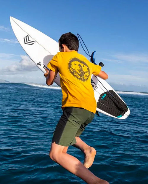 Person jumping into the ocean with a surfboard.