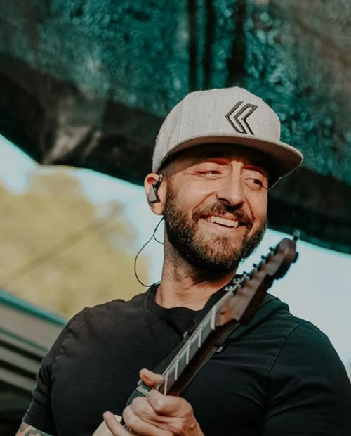 Man holding a guitar with a blurred background