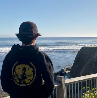 Surf check in the Mad Otter hooded black sweatshirt